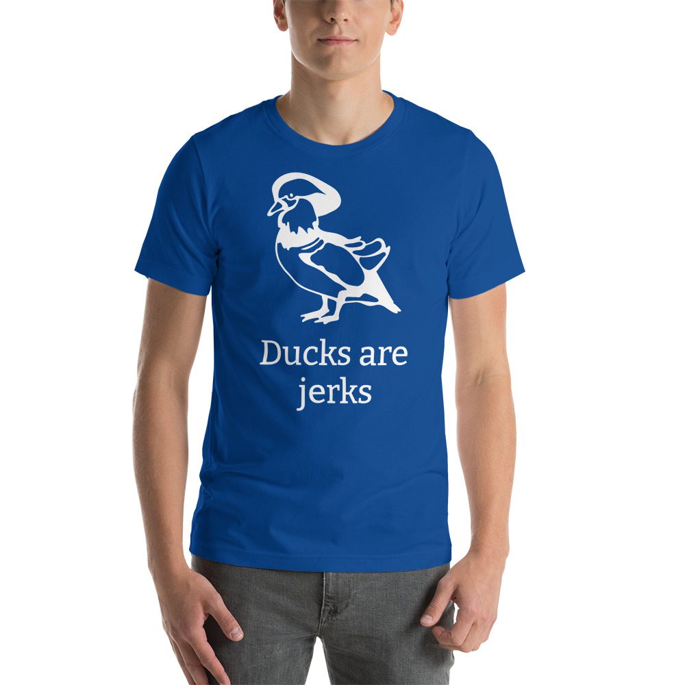 Unisex t-shirt with a picture of a duck on it. Underneath t says "Ducks are jerks."